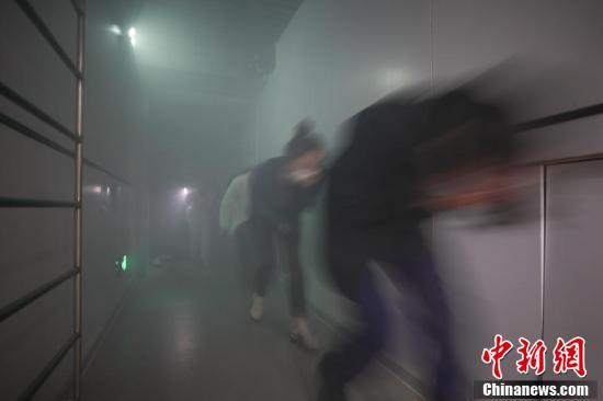 參觀(guān)者在進(jìn)行“煙道逃生技術(shù)訓(xùn)練”